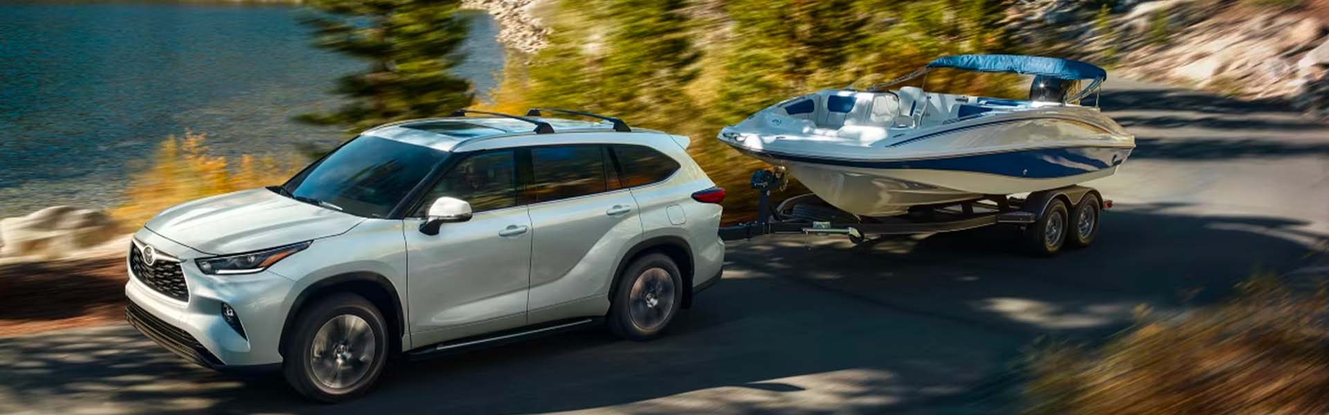 a white toyota highlander hauling a speed boat
