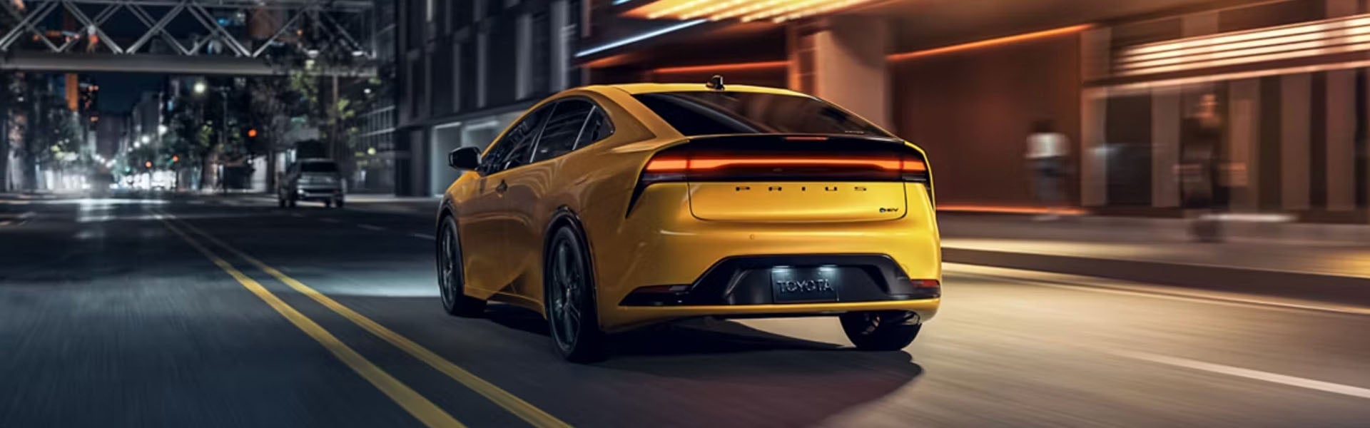 A yellow car driving on the road.