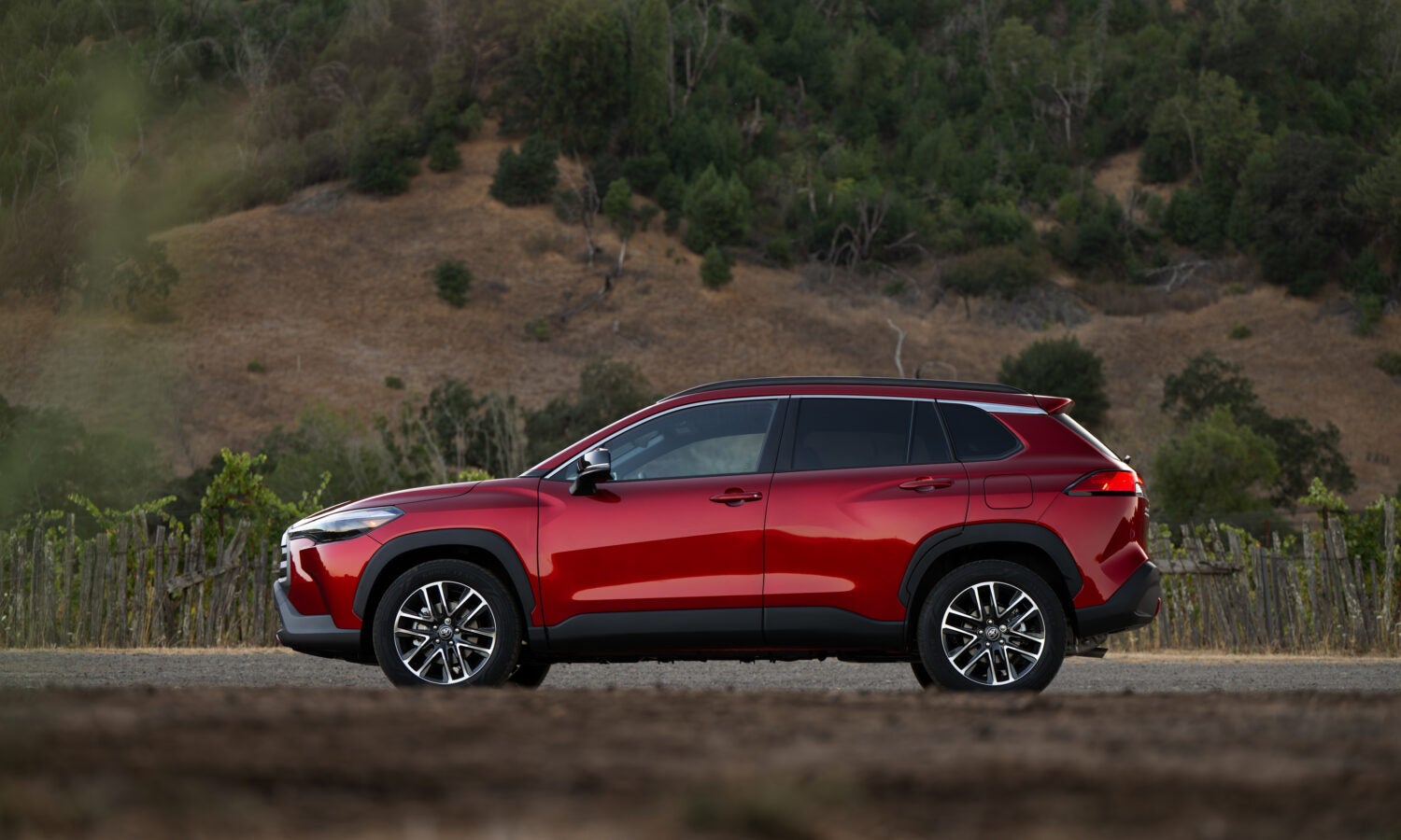 a red 2026 toyota corolla cross parked in a field