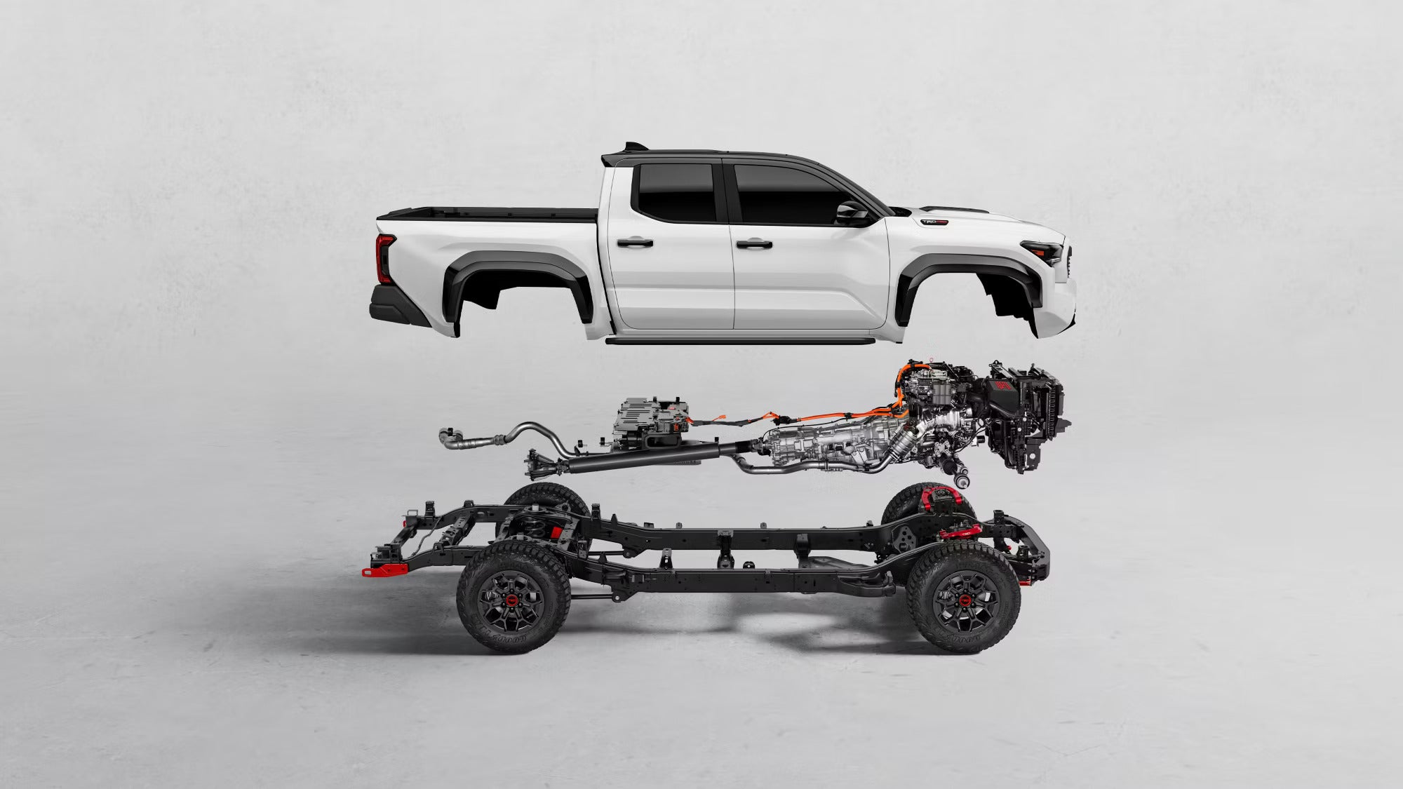 Exploded view of a Toyota truck showcasing the body, engine, and chassis components against a white background.