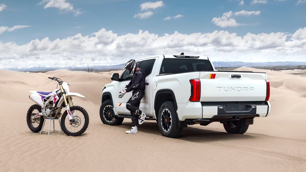 2025 Toyota Tundra TRD Pro in a desert setting next to a dirt bike, highlighting its off-road capability