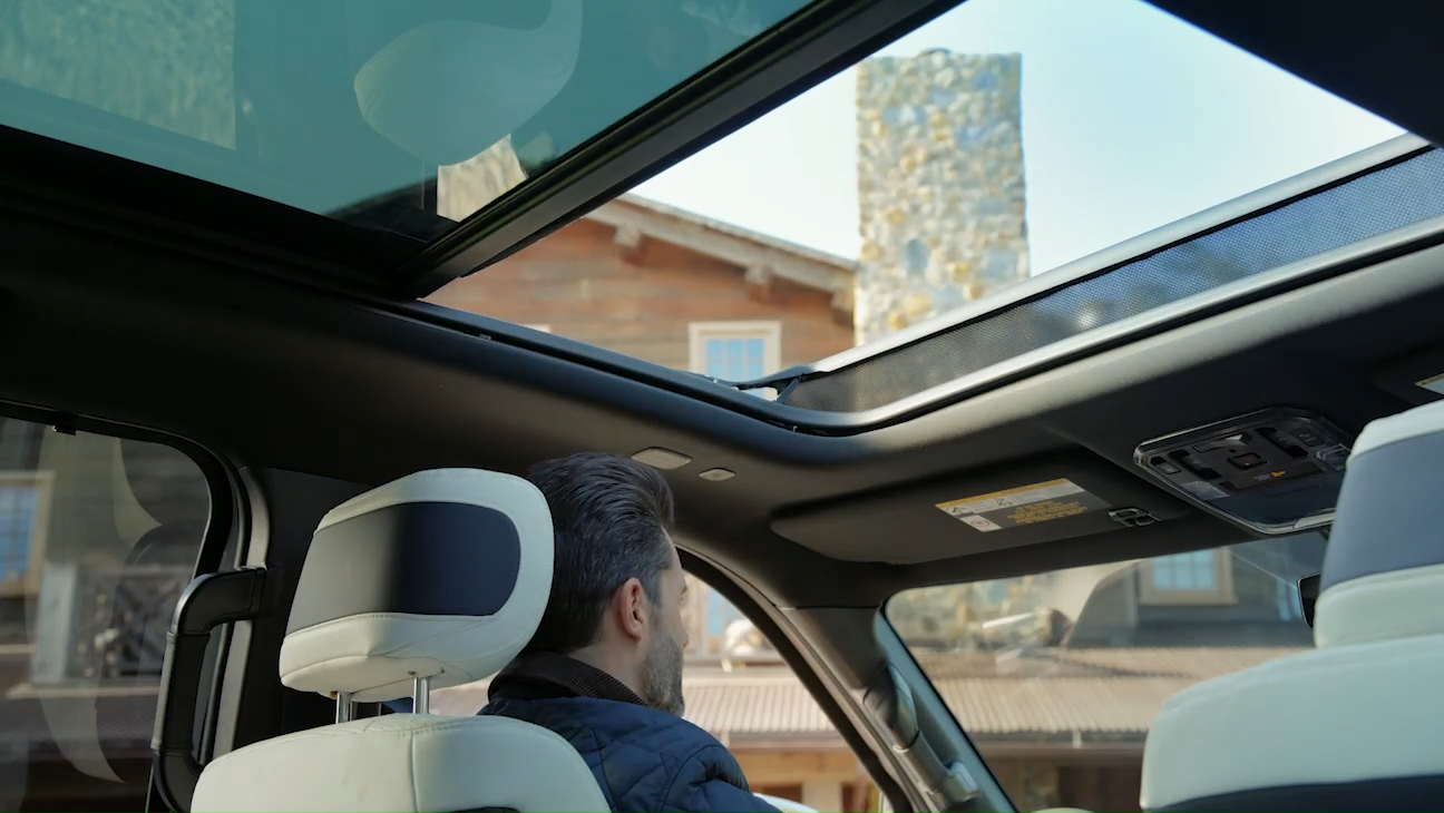 View of the 2025 Toyota Tundra's panoramic sunroof with a driver enjoying the open sky