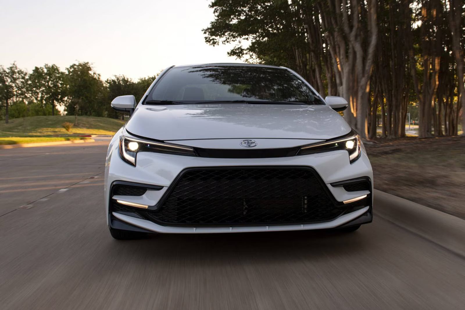 A white car driving on the road.