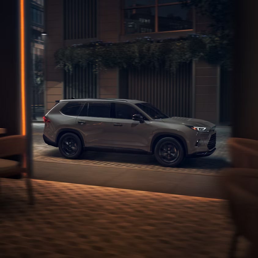 A gray suv sitting in the road.