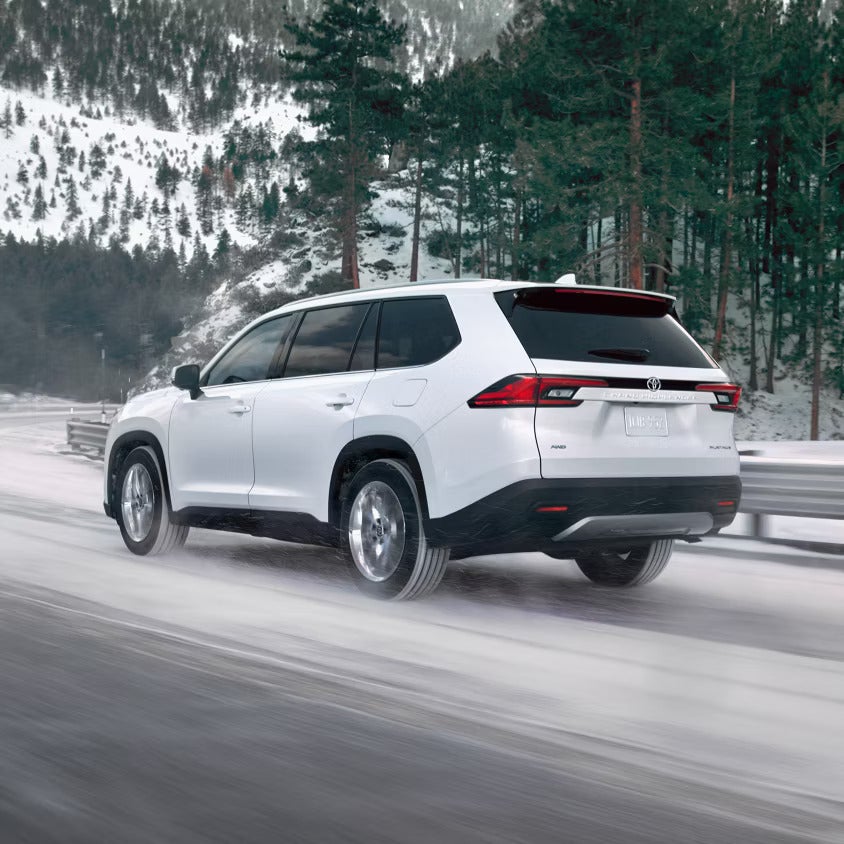 A white suv driving on the road.