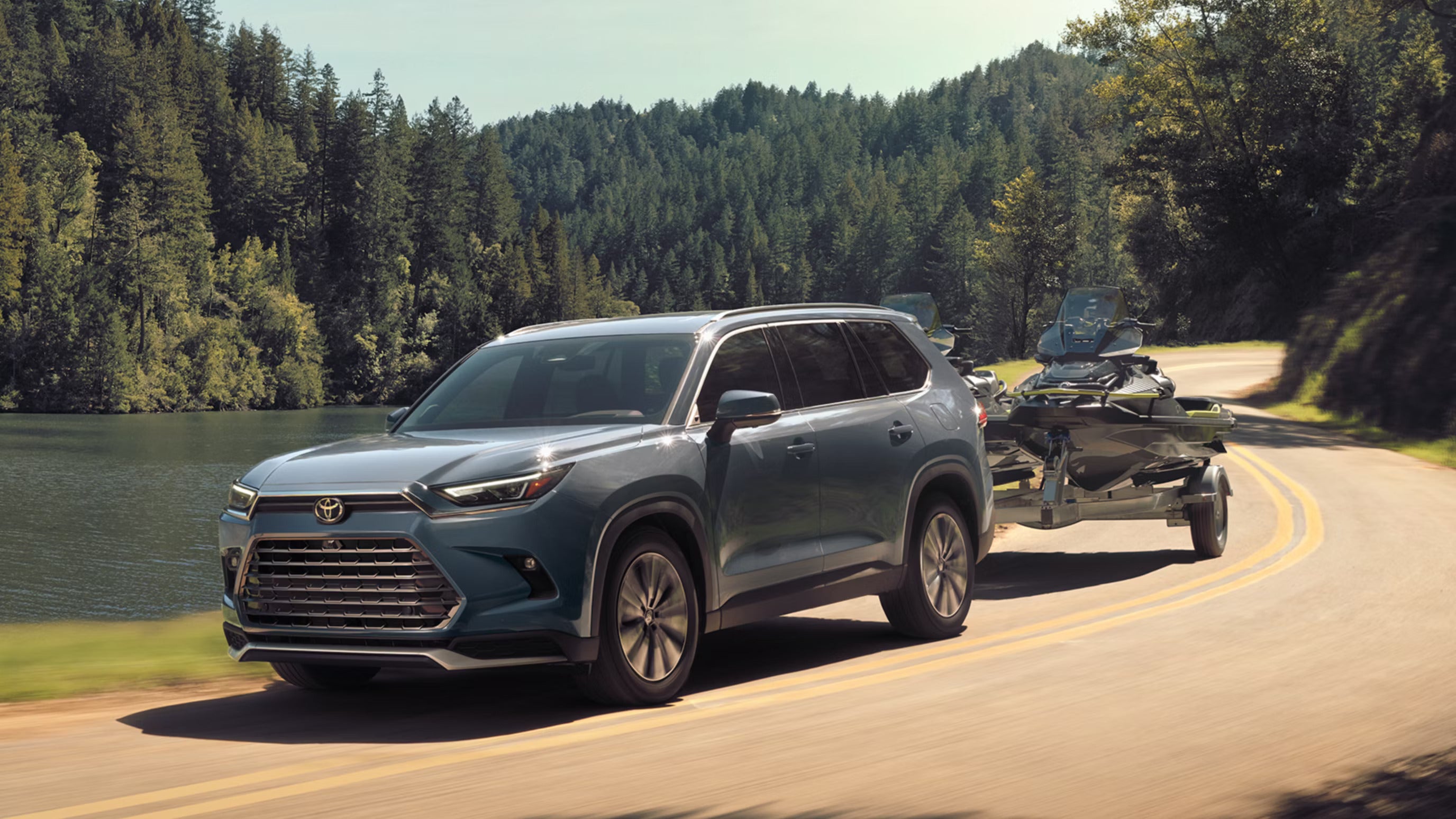 A suv pulling a jet ski down the road.