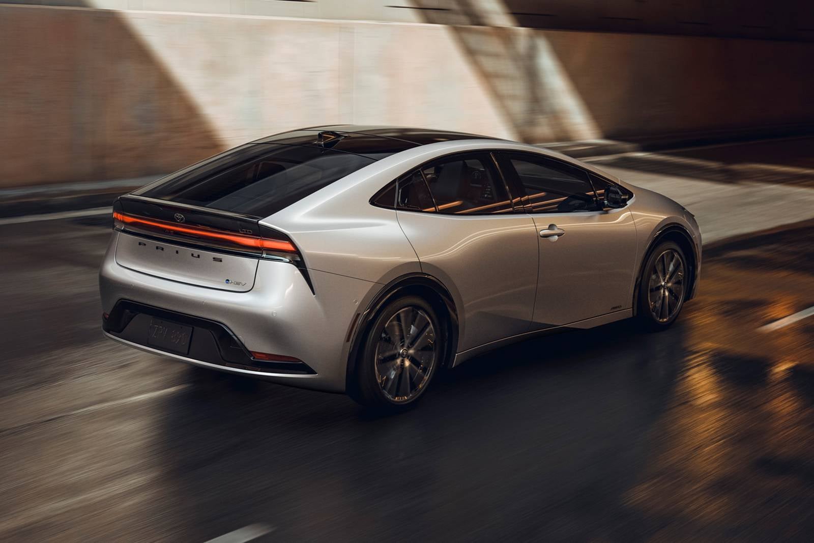 A silver car driving on the road.