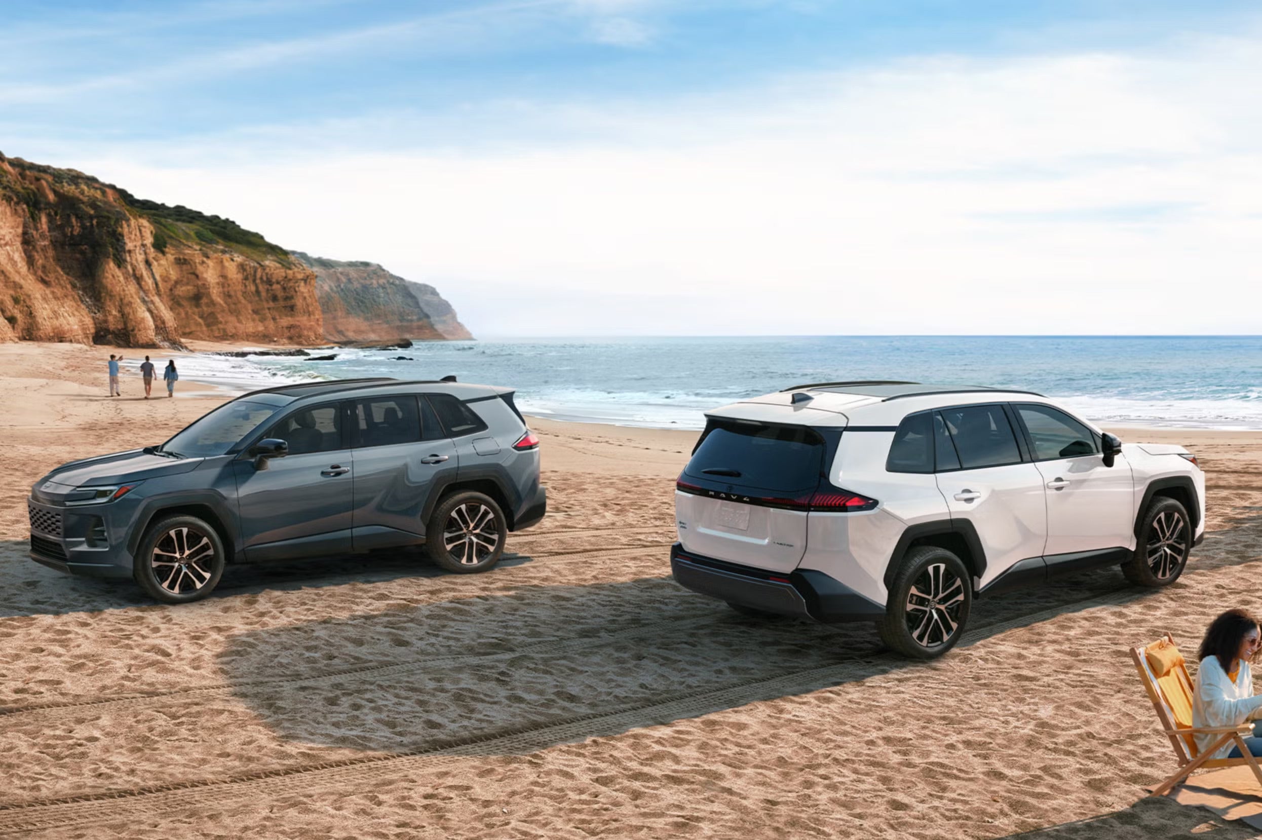 Two suvs sitting parked on the beach.