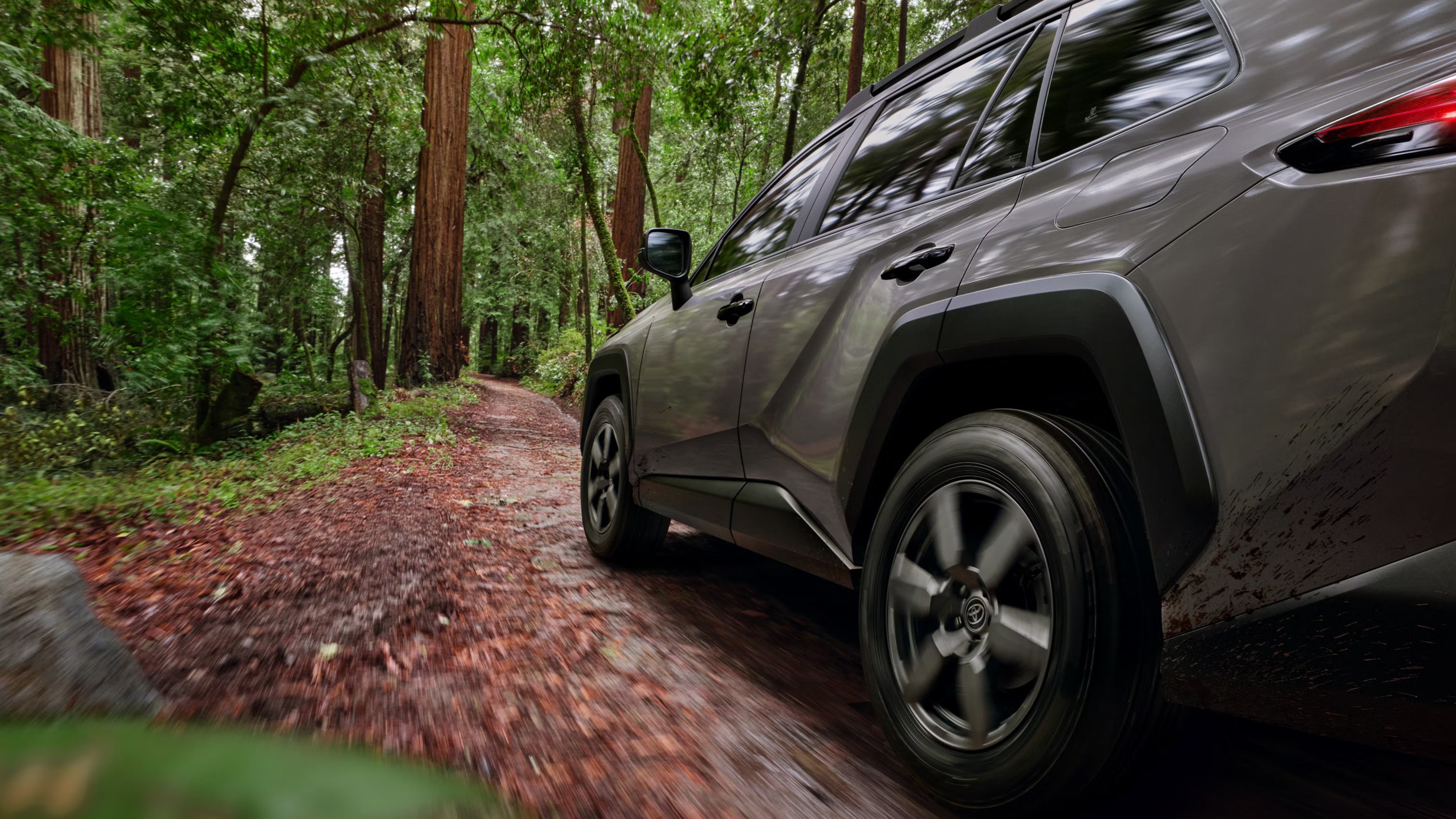 A green suv driving off-road.