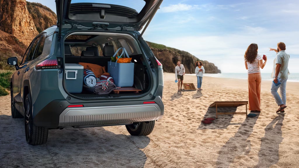 The trunk open on a rav4 on the beach.