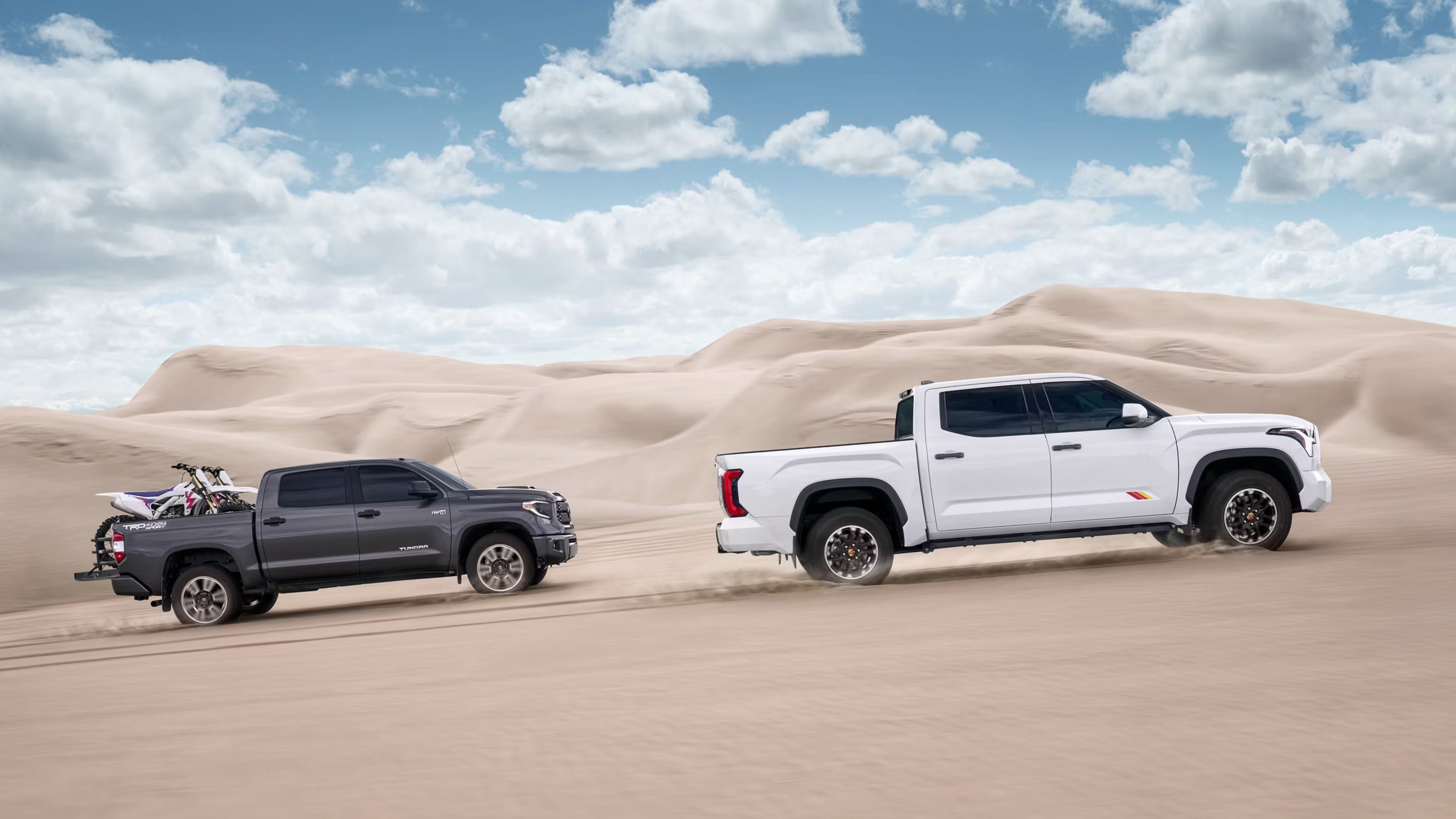 Two trucks driving off-road.