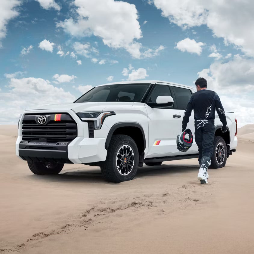 A man walking towards a white truck.