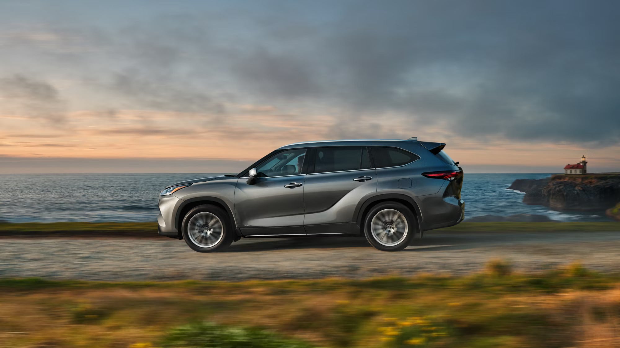 A silver suv driving on the road.