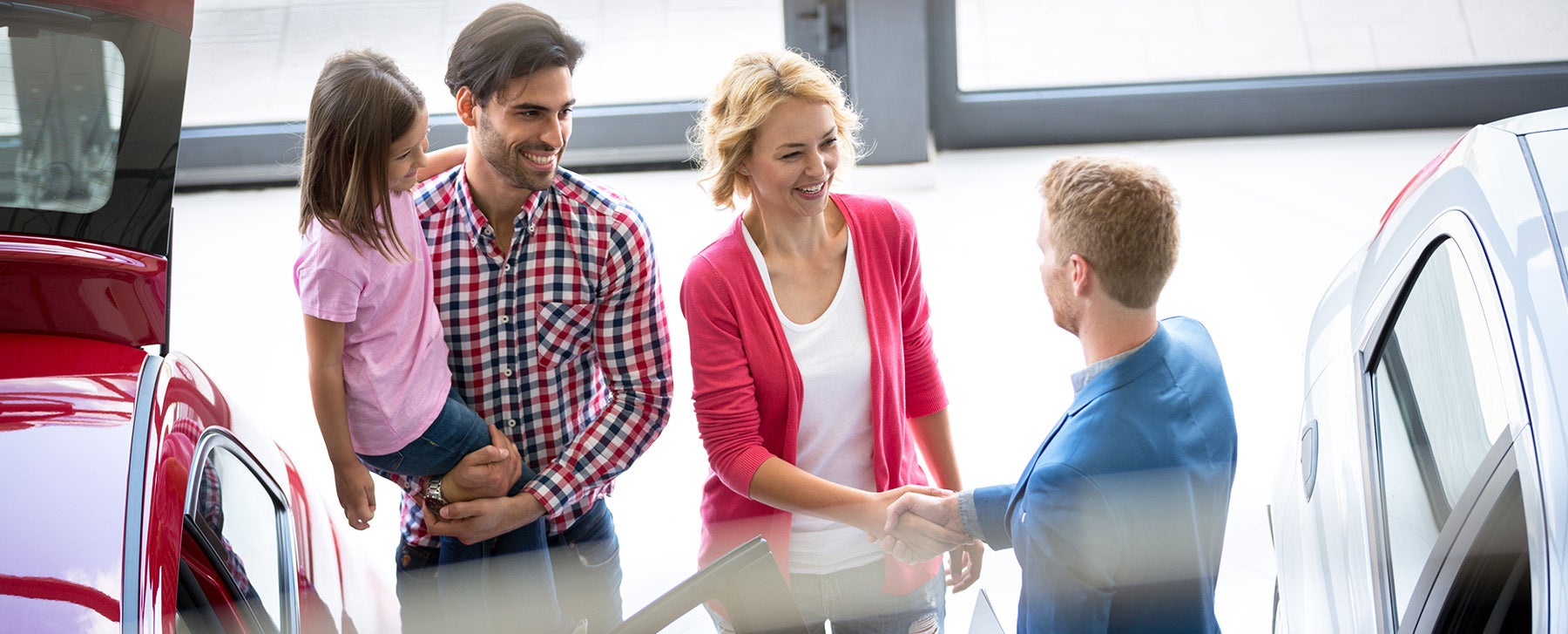 a family getting keys to a vehicle from a dealership representative