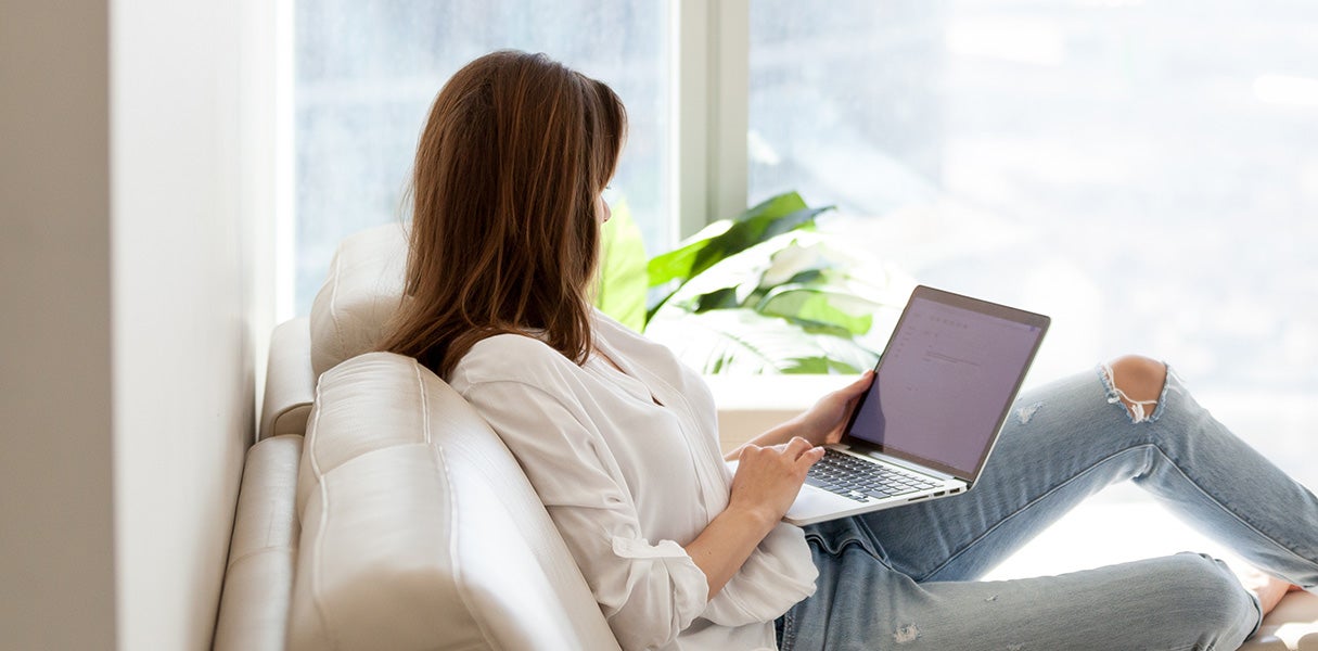 a woman sitting on a couch with a laptop in her lap